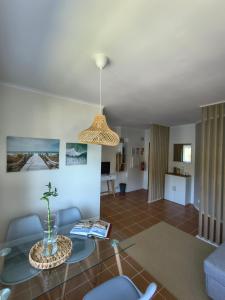 ein Wohnzimmer mit einem Glastisch und blauen Stühlen in der Unterkunft Cabedelo River Flat in Darque