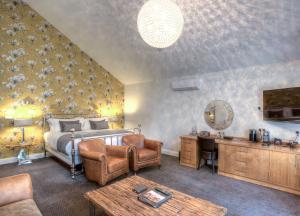 Dormitorio con cama, escritorio y TV en Fonab Castle Hotel, en Pitlochry