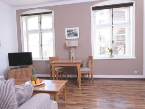 a living room with a table and a tv at Courtyard Idyll Apartment in Rostock