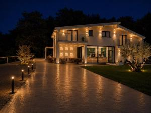 a house at night with lights on a driveway at The Queen Oak - nature relais in Santa Marina