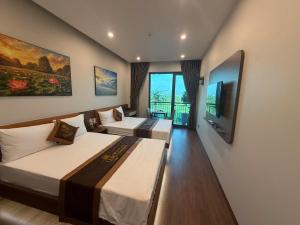a hotel room with two beds and a flat screen tv at A30 Hotel & Apartment in Lưu Xá