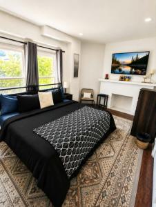 a bedroom with a large black bed and a fireplace at The Victorian House in Buffalo