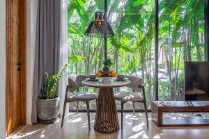 a table with fruit on it in a room with a large window at Sebelas Apartments by EVDEkimi - Modern Stay with Pool near Dining & Shops in Ubud