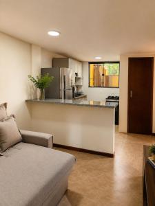 a living room with a couch and a kitchen at Refúgio das Rosas in Pedro do Rio