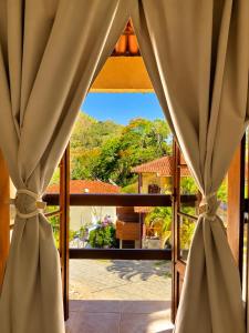 a room with a window with a view of a garden at Refúgio das Rosas in Pedro do Rio