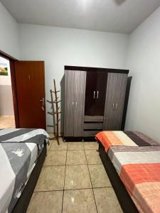 a bedroom with two beds and a dresser at ''Pousada Rosa Amiga'' in Barretos