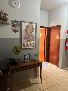 a room with a table and a picture on the wall at ''Pousada Rosa Amiga'' in Barretos