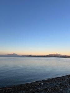 a large body of water with mountains in the background at Ruta Pata Austral in Puerto Varas