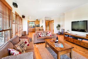 a living room with couches and a flat screen tv at BullerRoo Luxury Chalet & Cottage Farmstay in Barwite
