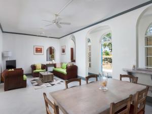 a living room with a table and chairs at Stunning Views Oceanfront Oasis with Private Pool - Inch by Inch in Christ Church