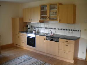 kuchnia z drewnianymi szafkami i zlewem w obiekcie Apartment Könighaus w mieście Sankt Michael im Lungau