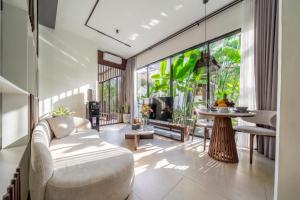 a living room with a couch and a table at Sebelas Apartments by EVDEkimi - Modern Stay with Pool near Dining & Shops in Ubud