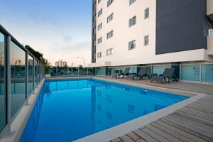 a swimming pool in front of a building at Harbourfront Views at Allure 2 Bedroom Apartment in Townsville