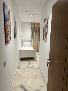 a room with a bed and paintings on the walls at belle appartement à centre Kénitra in Kenitra