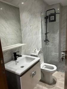 a bathroom with a white sink and a toilet at belle appartement à centre Kénitra in Kenitra