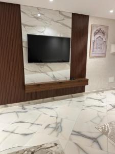 a living room with a television and marble floors at belle appartement à centre Kénitra in Kenitra +15 photos