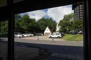 a window view of a parking lot with cars parked at Kusatsu Onsen Eidaya in Kusatsu