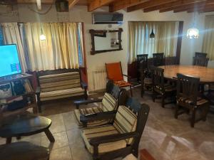 a living room with a table and chairs and a television at LA CASONA in Villa General Belgrano