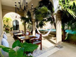 a restaurant with tables and chairs and palm trees at The Diplomat Boutique Hotel in Mérida