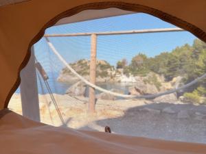 a window in a tent looking out at a river at Albania Glamping in Himare