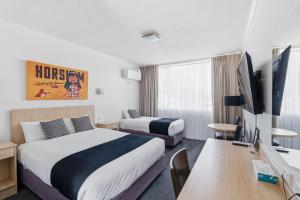 a hotel room with two beds and a flat screen tv at The Capital Horsham in Horsham