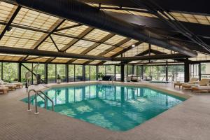 a large swimming pool in a building with windows at Madison Marriott South in Madison