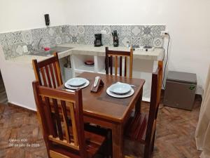 a kitchen with a wooden table and chairs and a kitchen counter at Secret Paradise Mahahual in Mahahual