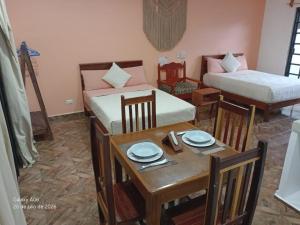 a room with two beds and a table and a dining room at Secret Paradise Mahahual in Mahahual