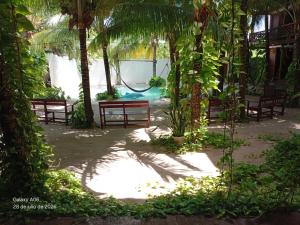 a park with benches and a playground with a swing at Secret Paradise Mahahual in Mahahual