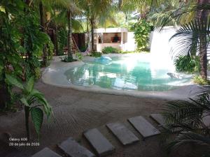 a swimming pool with a waterfall in a resort at Secret Paradise Mahahual in Mahahual