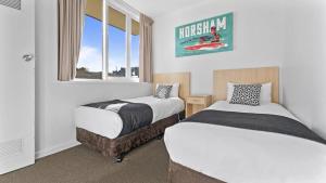 a room with two beds and a window at The Capital Horsham in Horsham