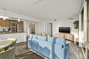 a living room with a blue couch and a kitchen at Hala Tysons in McLean