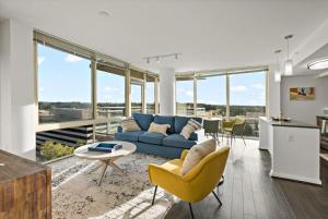 a living room with a blue couch and yellow chairs at Hala Tysons in McLean