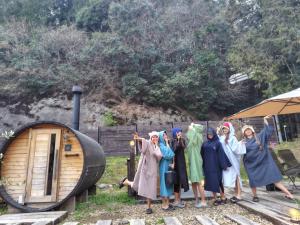 a group of women standing next to a barrel at 本格貸切サウナの宿 つづやビレッジ in Minokamo
