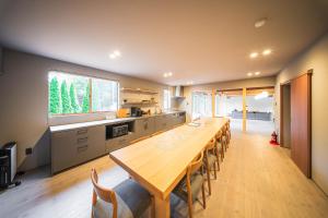 a large kitchen with a long wooden table and chairs at Tanglin Maison Hakuba by Jade Villa in Hakuba +27 photos