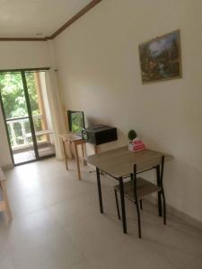 a living room with a wooden table and a desk at Gemini Hotel & Restaurant in Libaong