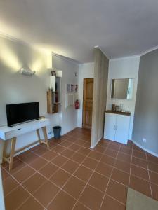 ein Zimmer mit Fliesenboden, Schreibtisch und Küche in der Unterkunft Cabedelo River Flat in Darque