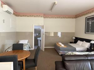 a hotel room with a couch and a bed and a table at The Avalon in Mount Gambier