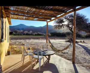 a patio with a table and chairs and a hammock at Cabañas Rurales HLS in Senador Pérez