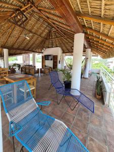 a patio with blue chairs under a thatched roof at Sicarú, La Punta - Puerto Escondido in Brisas de Zicatela +22 photos
