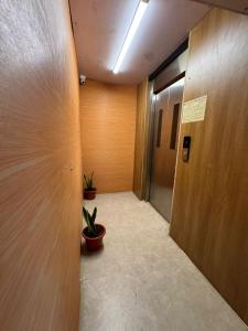 a hallway with two potted plants and a elevator at Laya Crest in Chennai