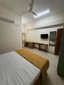 a bedroom with a bed and a flat screen tv at Laya Crest in Chennai