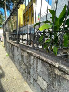a fence on a brick wall with a plant at Recanto Boa Vista in Recife