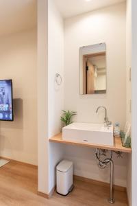 a bathroom with a white sink and a mirror at New! 3A Home 難波&道頓堀直通 2LDK一棟貸切 最大4名 in Osaka