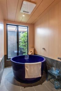 a large blue tub in a bathroom with a window at New! 3A Home 難波&道頓堀直通 2LDK一棟貸切 最大4名 in Osaka