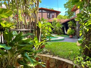 a garden with a fence and a house at Pousada Ibirapuera in Jericoacoara