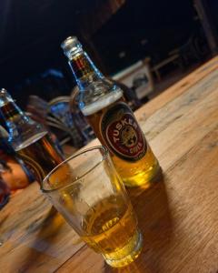 a bottle of beer and a glass on a table at Riverside chania resort in Nyeri