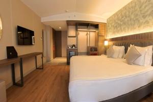 a large bedroom with a large bed and a kitchen at Ramada Encore by Wyndham Konya Selcuklu in Konya +22 photos