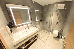 a bathroom with a sink and a shower and a toilet at Ramada Encore by Wyndham Konya Selcuklu in Konya