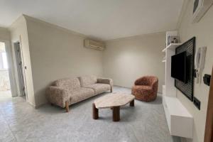 a living room with a couch and two chairs and a tv at TRYP by Wyndham Didim in Didim +24 photos